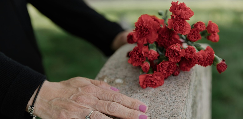 Person Touching a Headstone